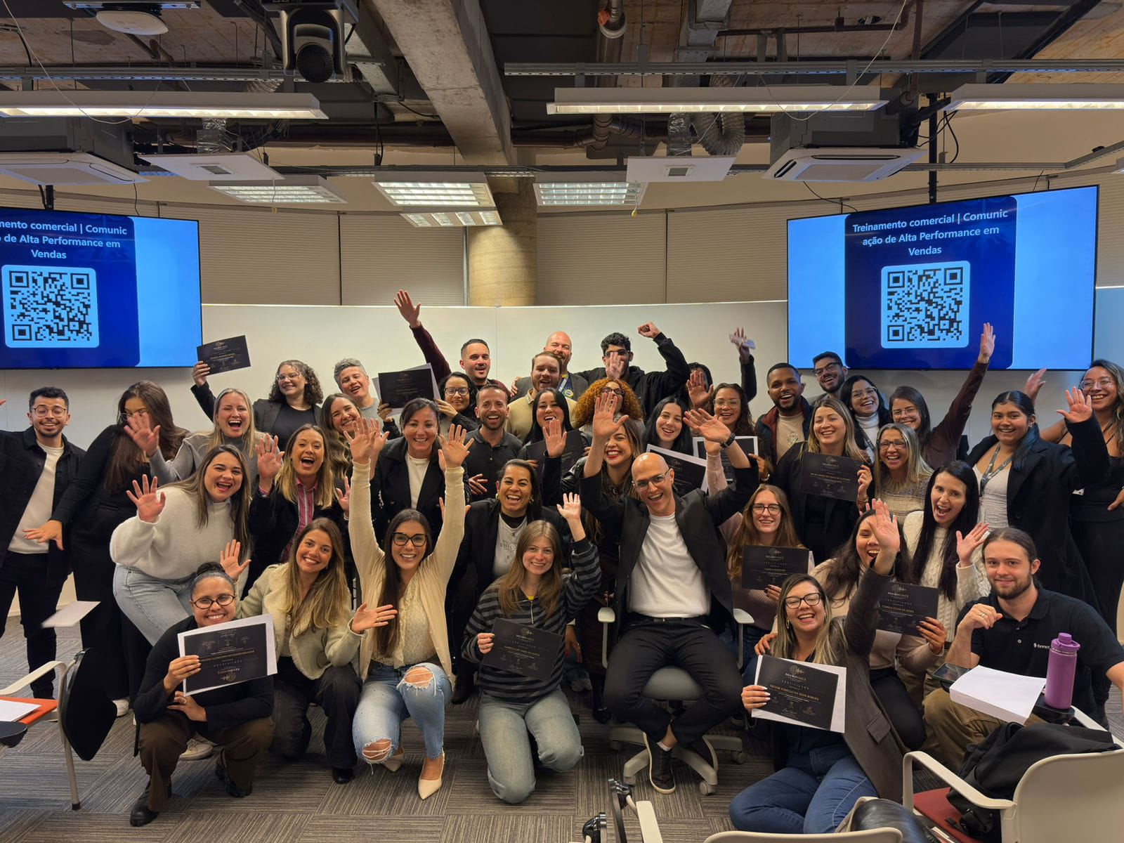 Turma de participantes com os certificados ao fim do treinamento